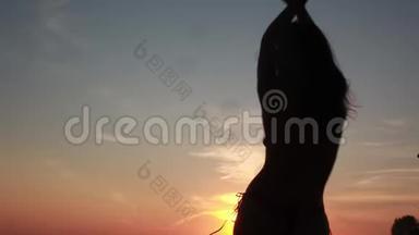 美丽的日落时分，比基尼女孩的剪影在海滩上翩翩起舞。1920x1080，高清